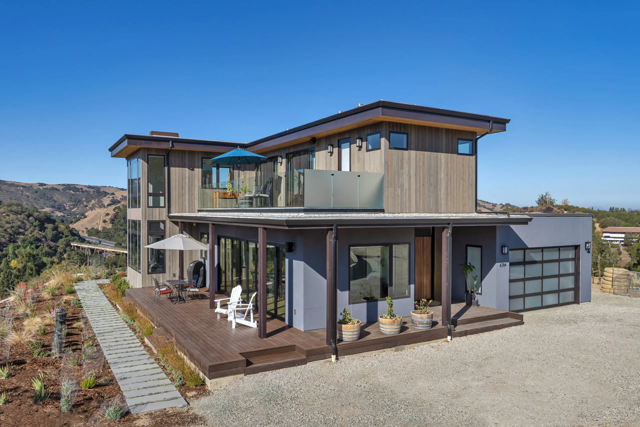 Modern style, two-story house in scrubland landscape.