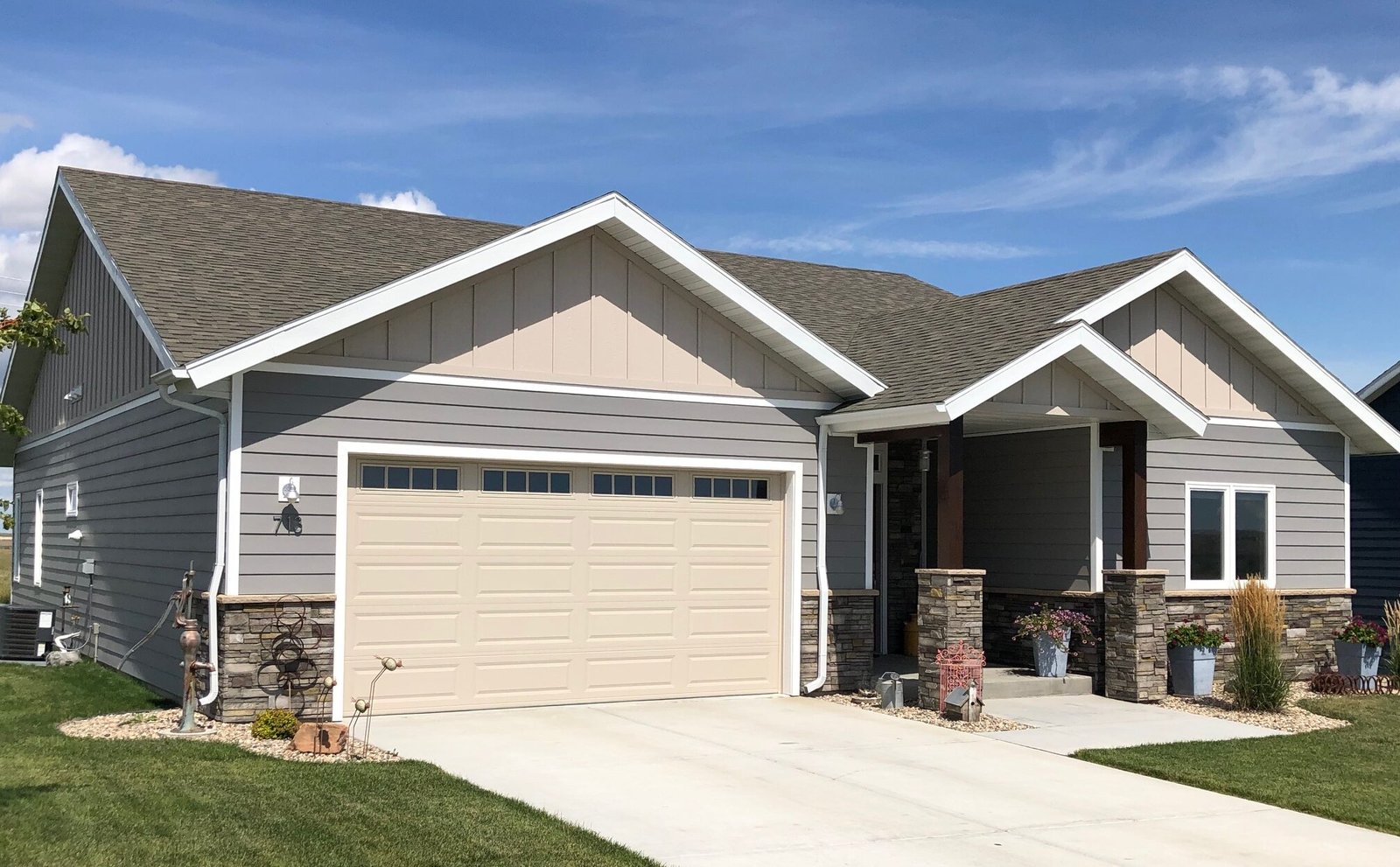 Exterior view of small suburban SIPs home with concrete drive and green lawn - photo