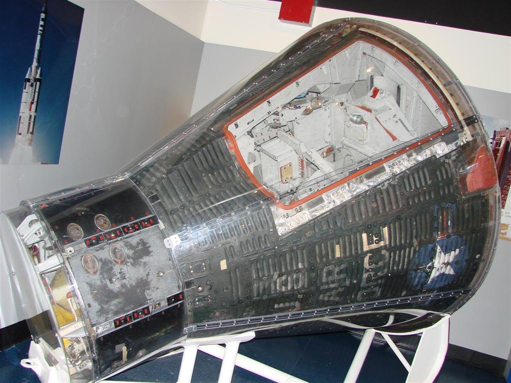 Image of a gray cone-shaped capsule on display in a museum.