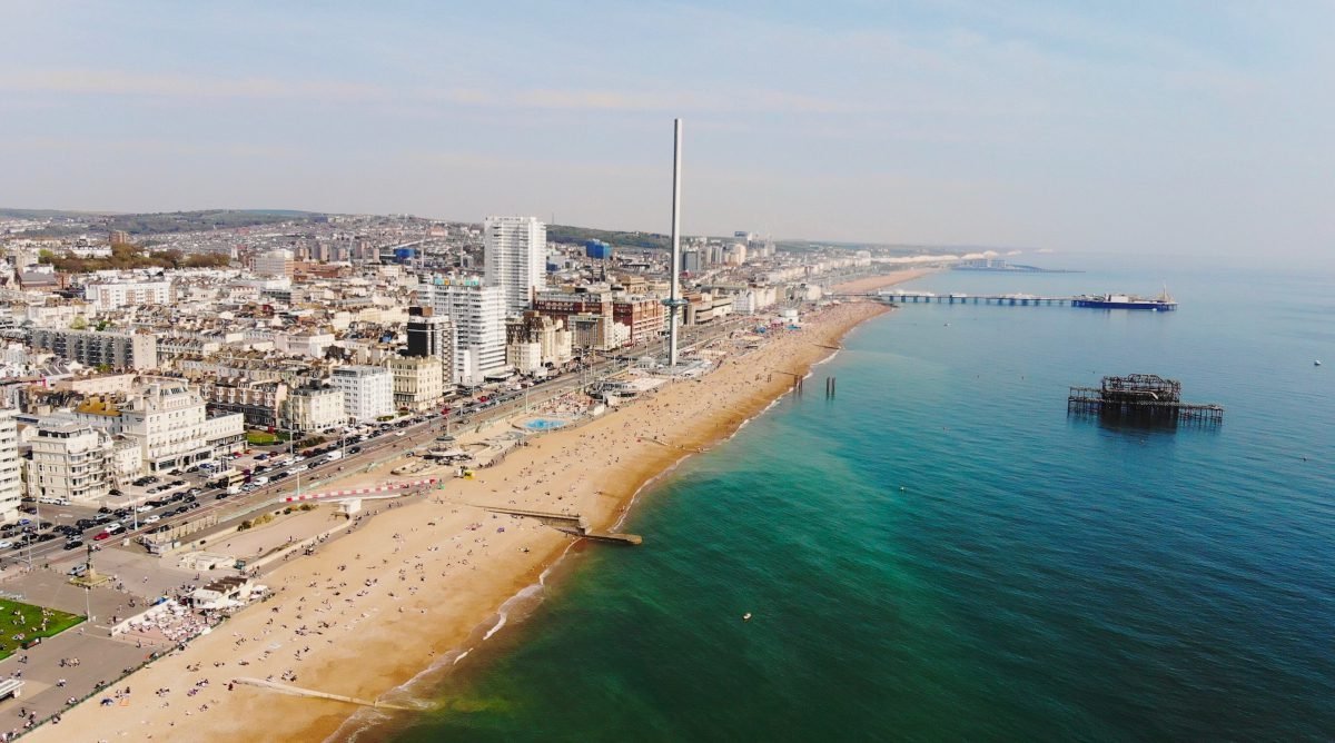 Aerial view of Brighton encompassing the South Downs, the city and the sea, with both piers visible