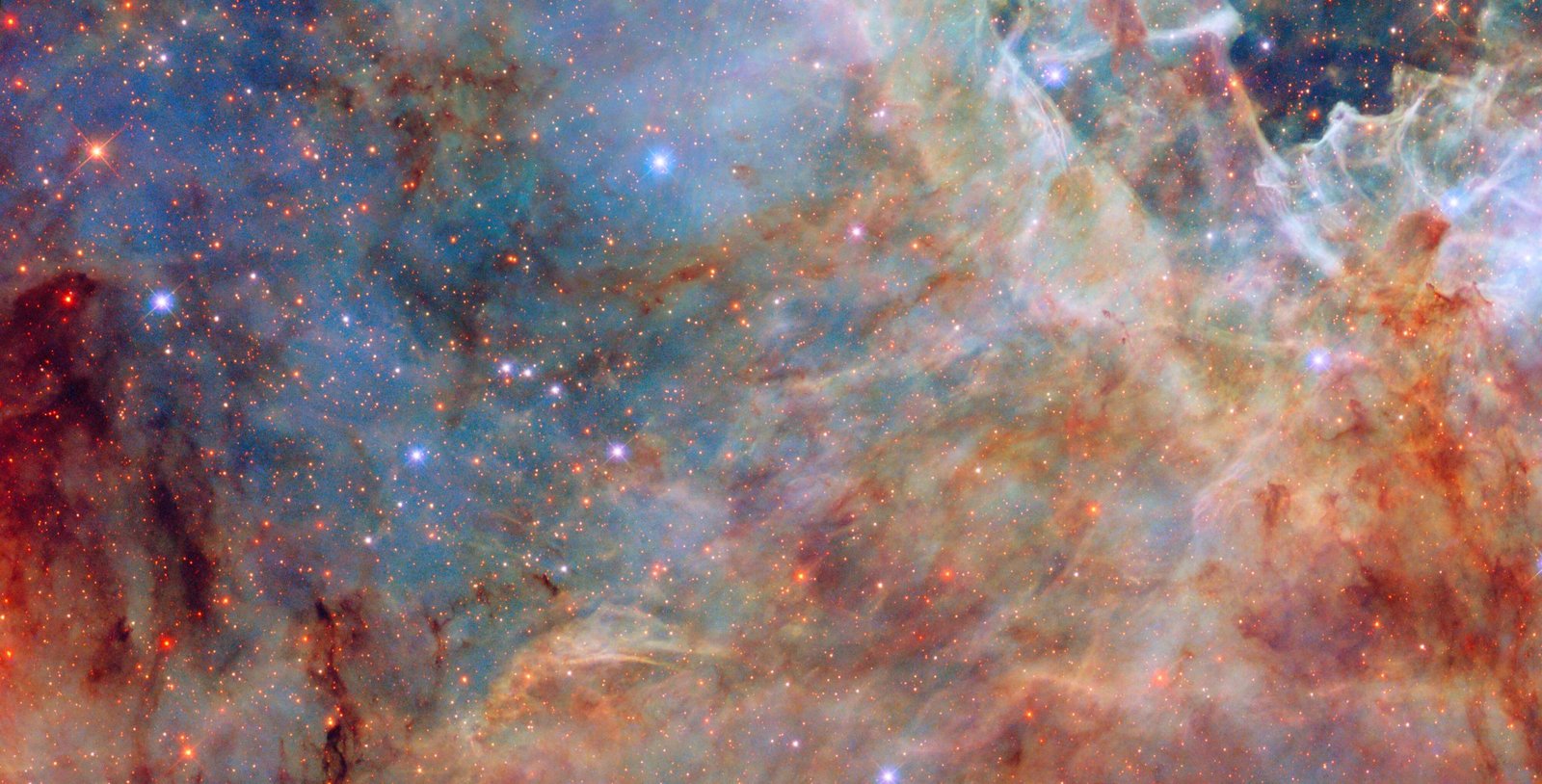 Shades of white, orange, and blue sweep across this view of the Large Magellanic Cloud. Blue and red stars peek through the clouds of gas and dust.