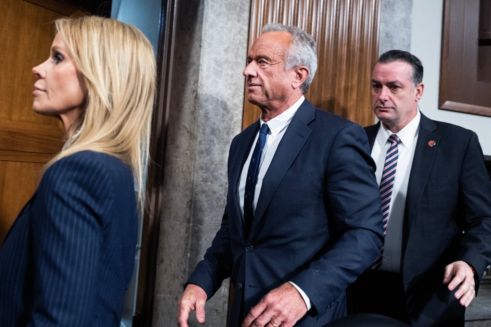 Robert F Kennedy, Jr. walks out of his senate confirmation hearing, accompanied by his wife Cheryl Hines