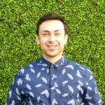 young man with brown hair wearing blue pattern shirt