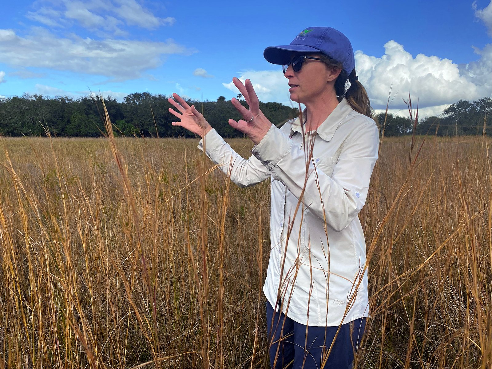 A woman stands in a field of grass