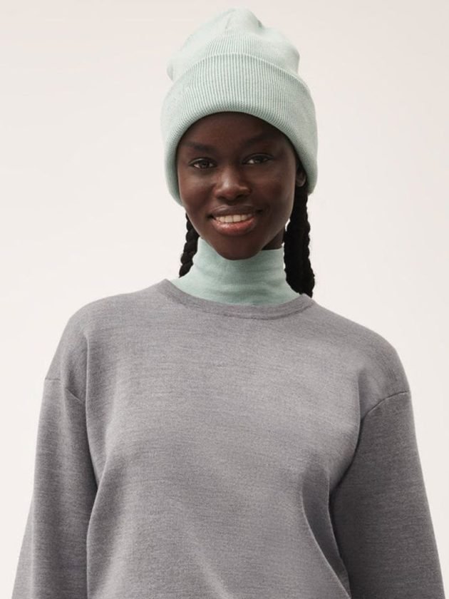 Model wearing mint regenerative wool beanie by PANGAIA