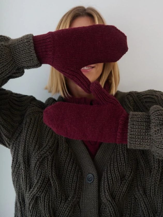 Model wearing burgundy handmade sustainable winter gloves by The Knotty Ones