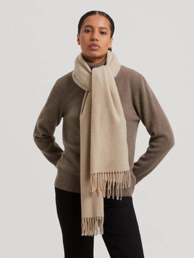 Model wearing beige cashmere wool scarf by ASKET