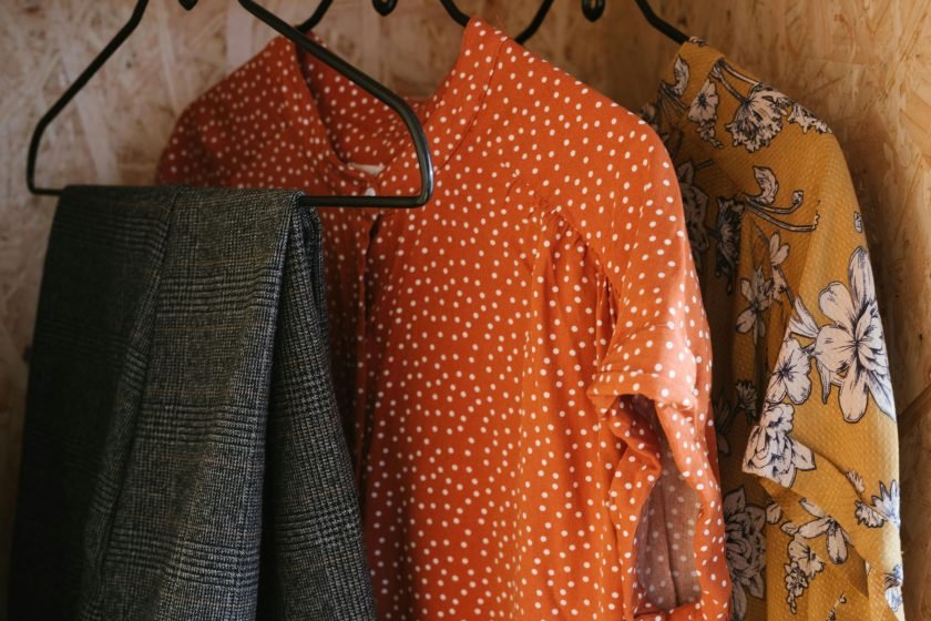 Trousers, dress, and blouse hanging in closet