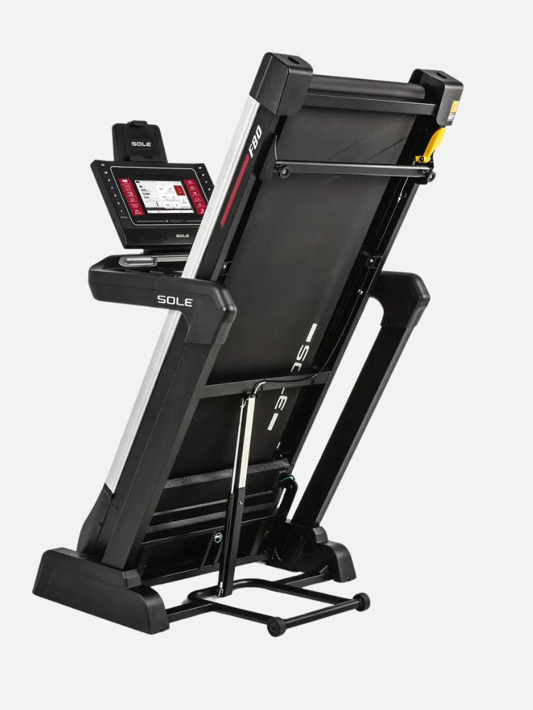 A black folding treadmill in an upright position, featuring a digital display and sturdy frame on wheels.