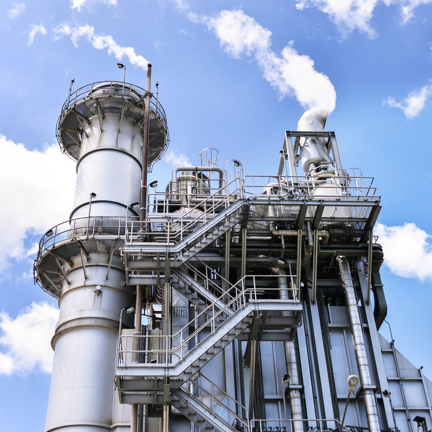 polluting gas peaker plant with blue sky above