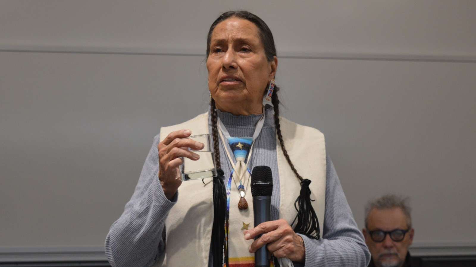 A woman standing in Indigenous dress.