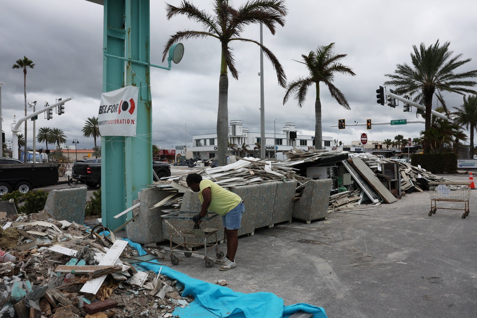 A resident of Treasure Island, Florida, cleans up debris from Hurricane Helene in September 2024 as she prepares for incoming Hurricane Milton. Local governments rely on FEMA to help them clear debris and rebuild infrastructure.