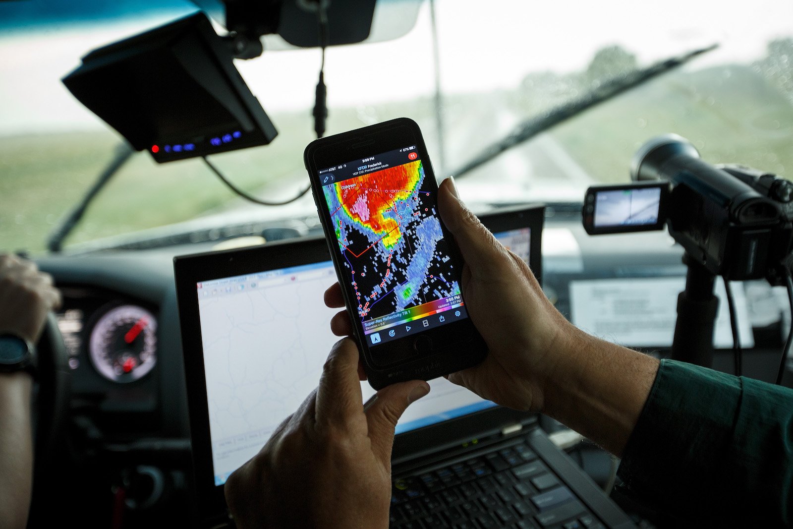 hands hold a smart phone with weather imaging on the screen
