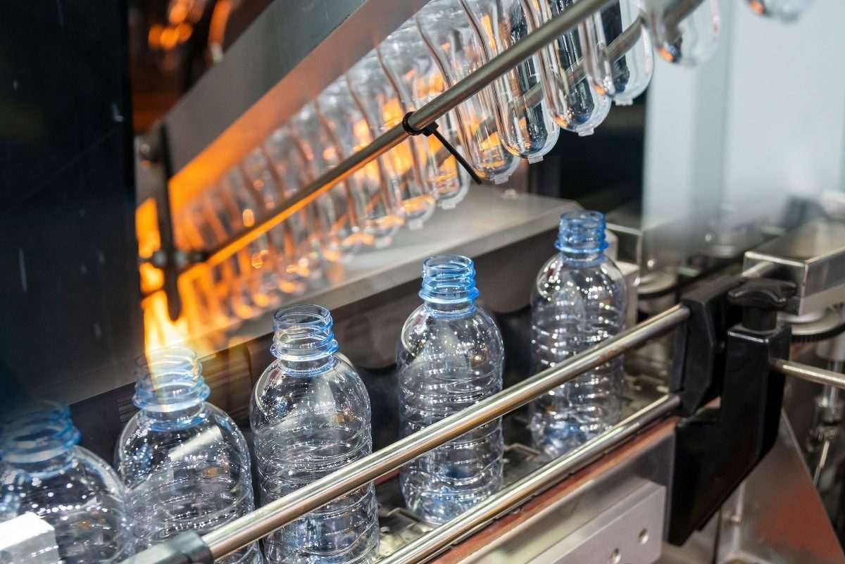 Plastic bottles arranged in single file within production equipment