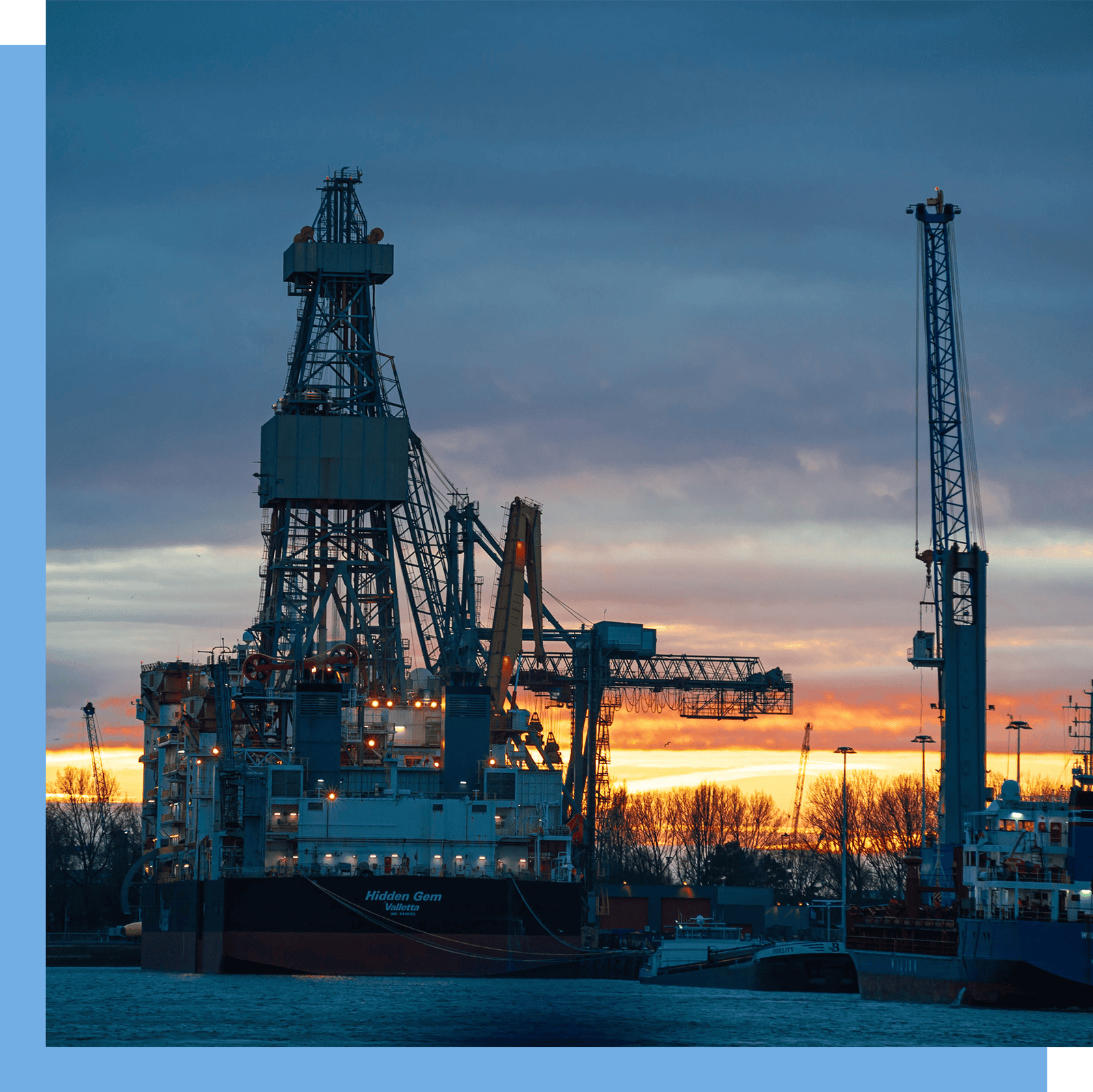 A square crop of a large deep sea mining ship on the water at sunset