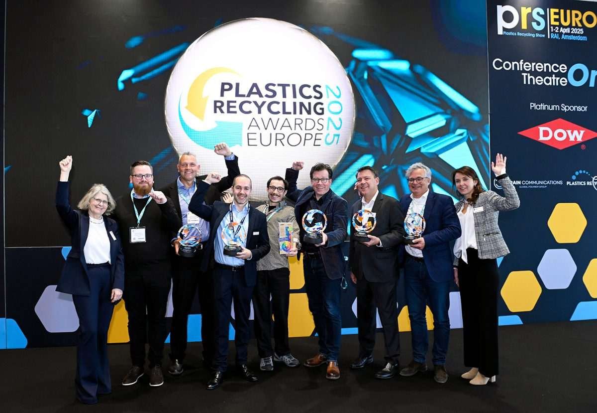 The eight winners of Plastics Recycling Europe standing on a stage with the awards logo behind them, and with all of them holding trophies, some of them making gestures of triumph