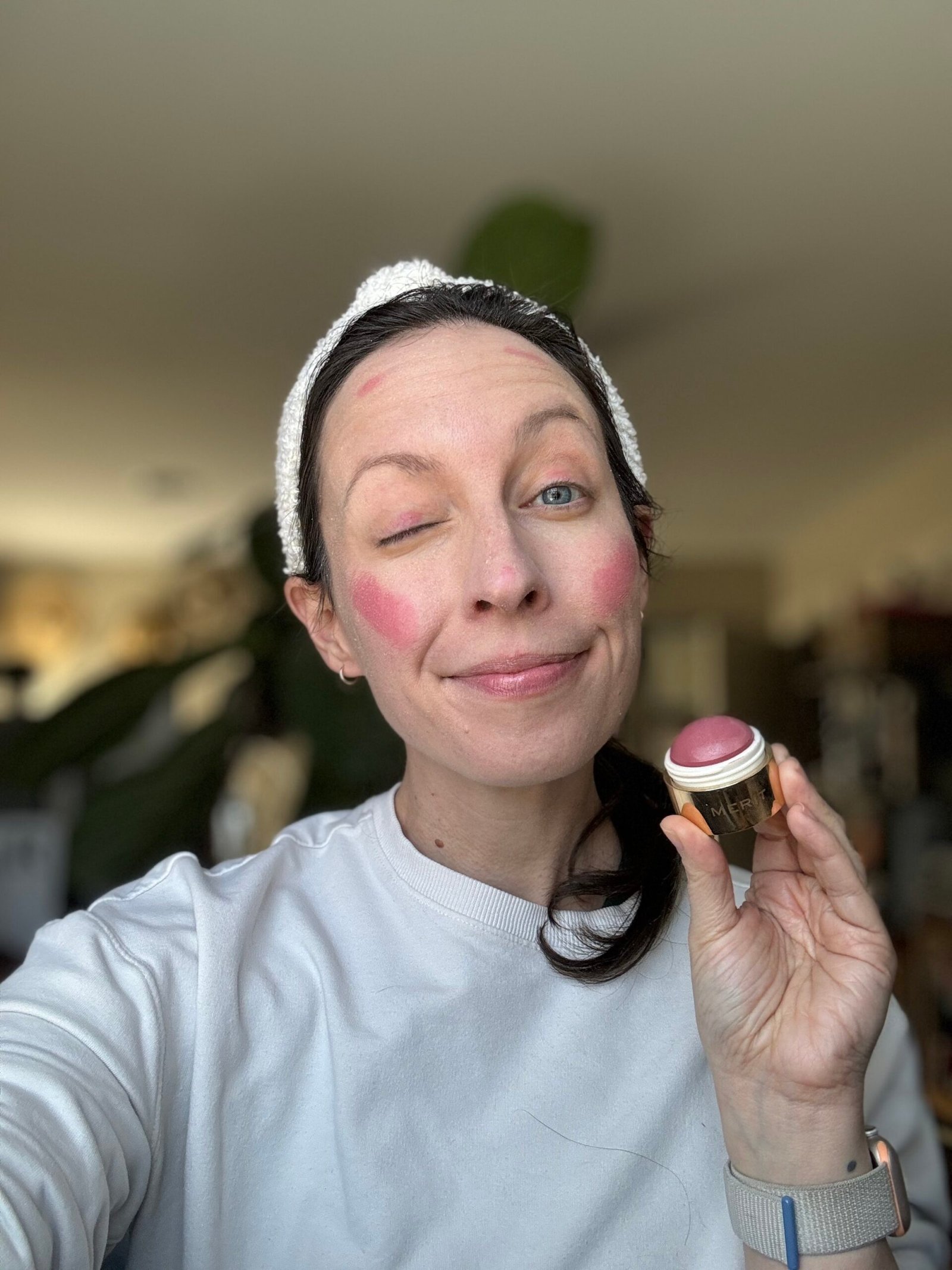 Woman applying blush to her cheeks with a brush.