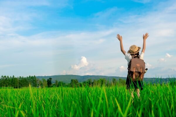 a woman in a field with her hands raised to the sky