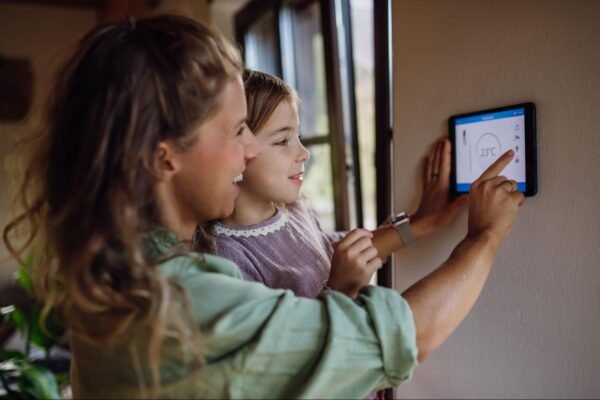 a mom holding her child, looking at a tablet