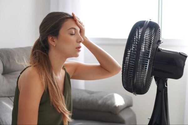 A woman sitting in front of a fan