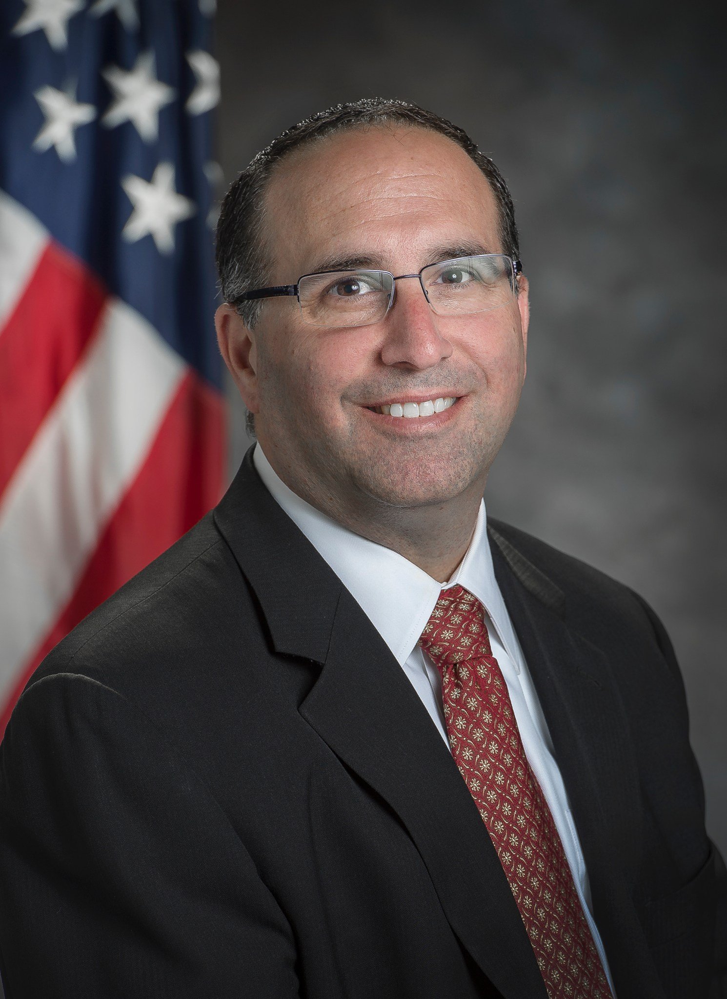 Erik Weiser poses In front of an American flag