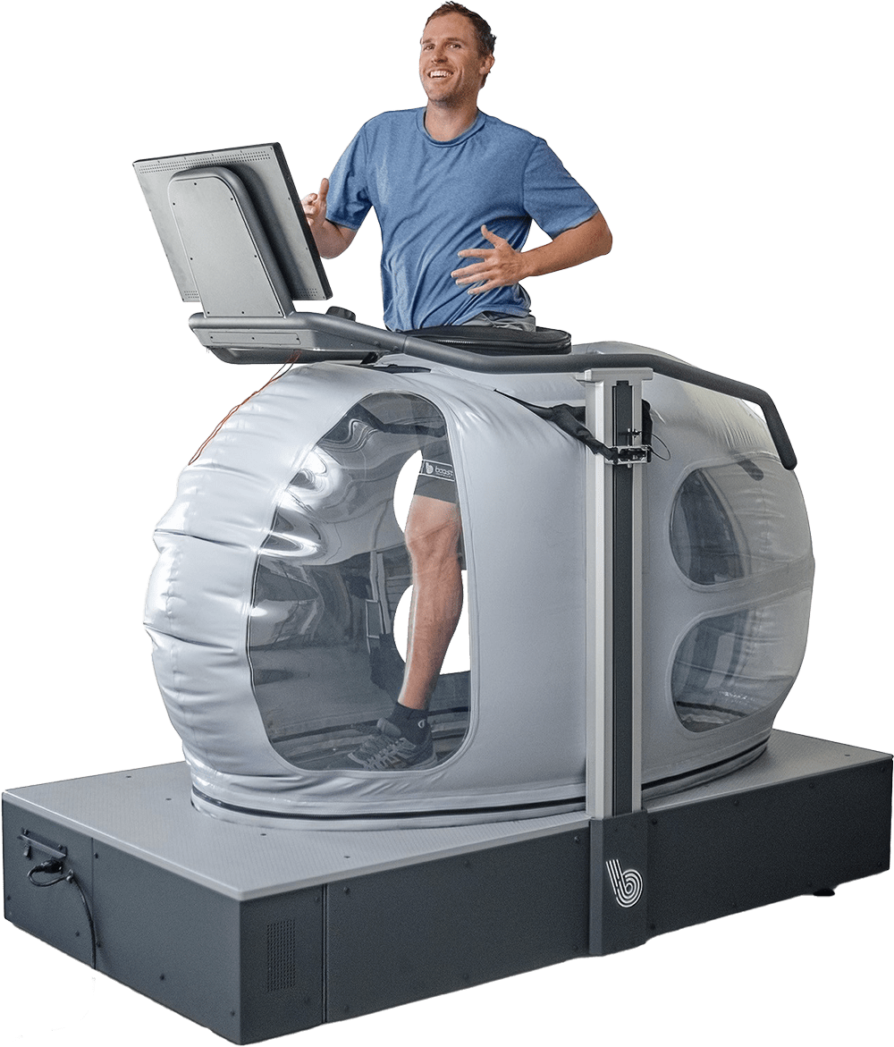 A man runs on a high tech treadmill, a large bubble-like structure surrounds his lower body