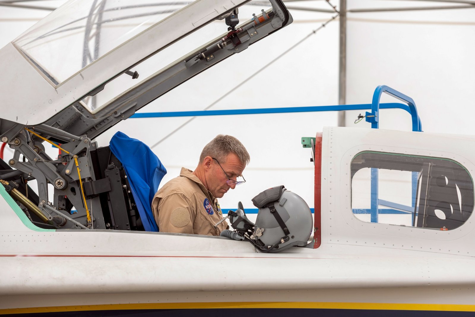 A NASA test pilot sits in the cockpit of a jet aircraft.