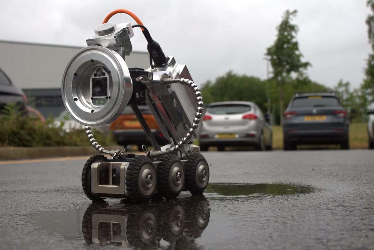 A seemingly compact, metallic assembly on a six-wheeled chassis with wires and different components visible