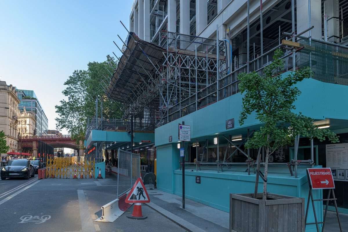 Scaffolding and green cladding visible on the facade of commercial building in London