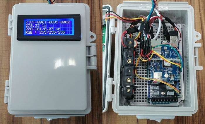 A small grey cuboidal box, the enclosure for an electronic sensor system appears on the left of the image, while the right shows the interior of the box, comprising wires and electronic or electrical components