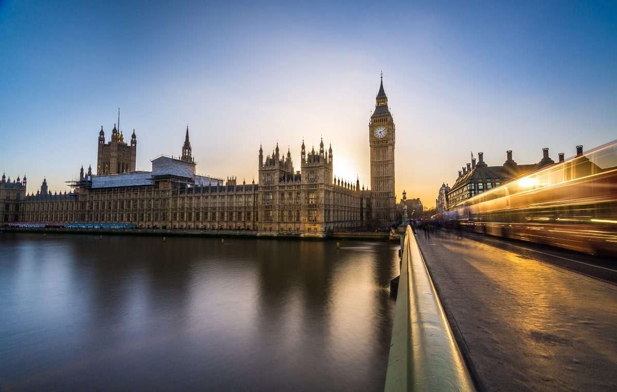 Houses of Parliament seen from the other side of Westminster Bridge with traffic headlights forming time-lapse diagonal lines of light on the bridge's extent