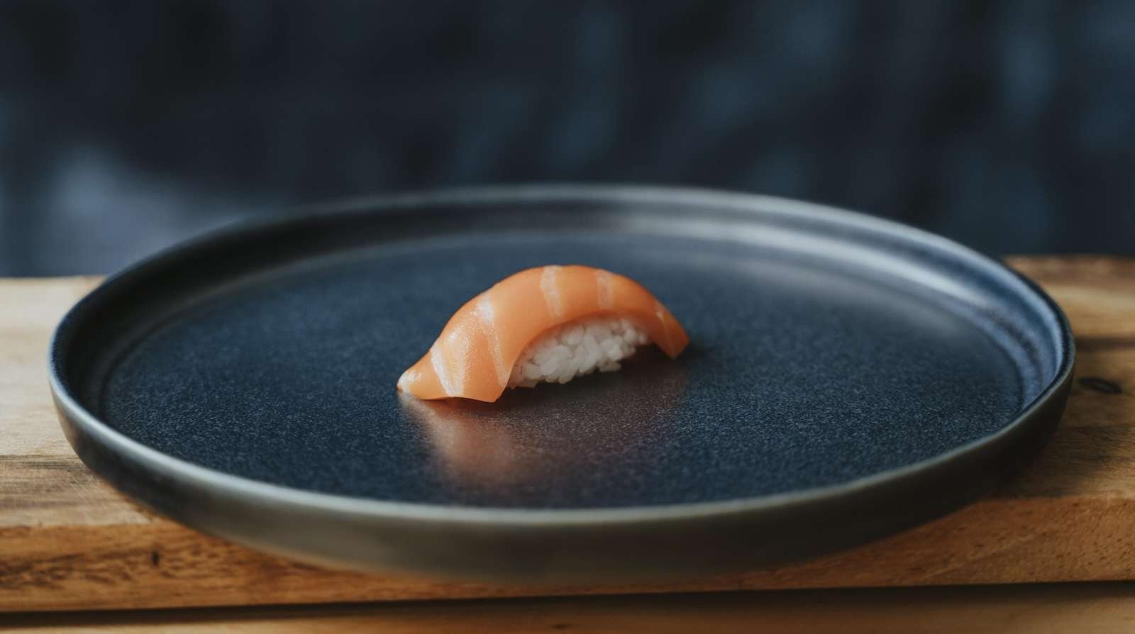 a piece of lab-grown salmon plated sashimi style on a large plate