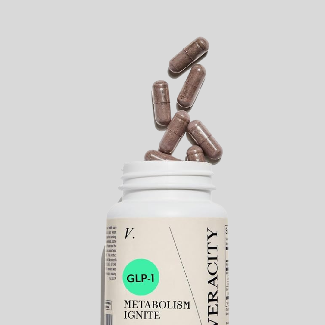 A white bottle labeled "Metabolism Ignite" with brown capsules emerging from the top, set against a plain grey background.