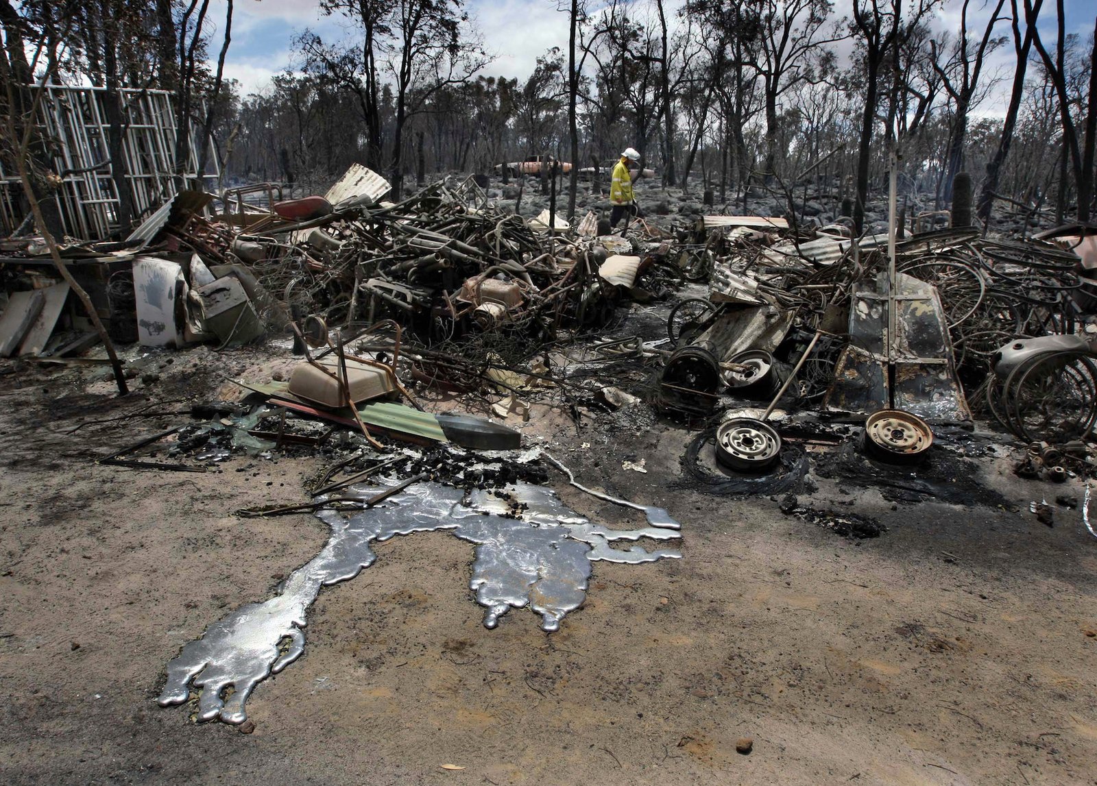 A firefighter picks his way through burned rubble