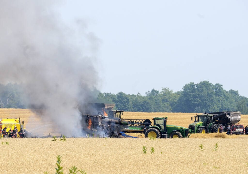 Firefighters from the Shelburne and District Fire Department attend to a fully engulfed combine in Amaranth Township wheat field. Quick thinking by farmers to furrow the ground around the blaze and efforts from firefighters prevented the fire from spreading to the dry wheat and stubble. August 5, 2025 Photo Diana Martin