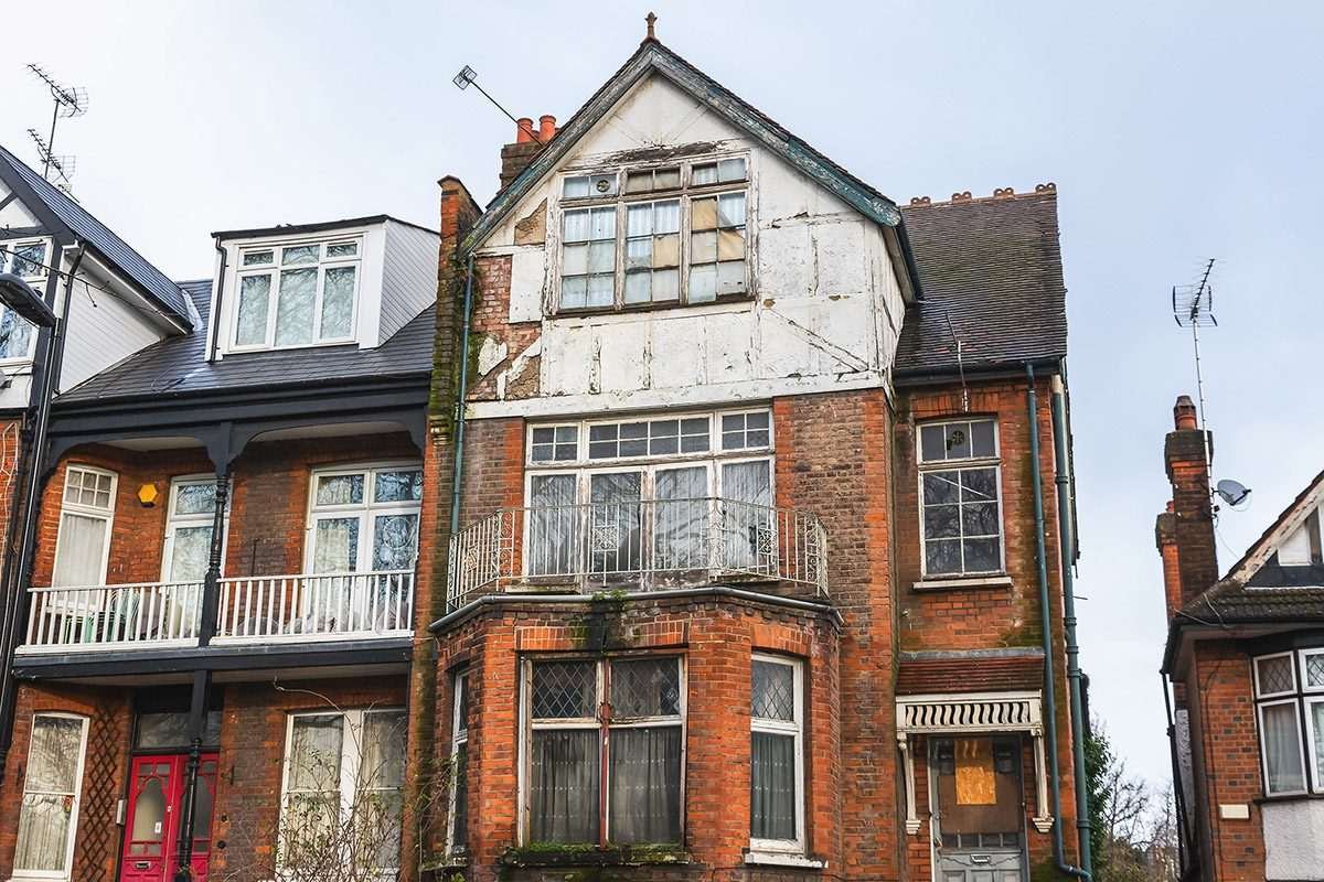 A dilapidated 3-storey house, red brick and English in appearance