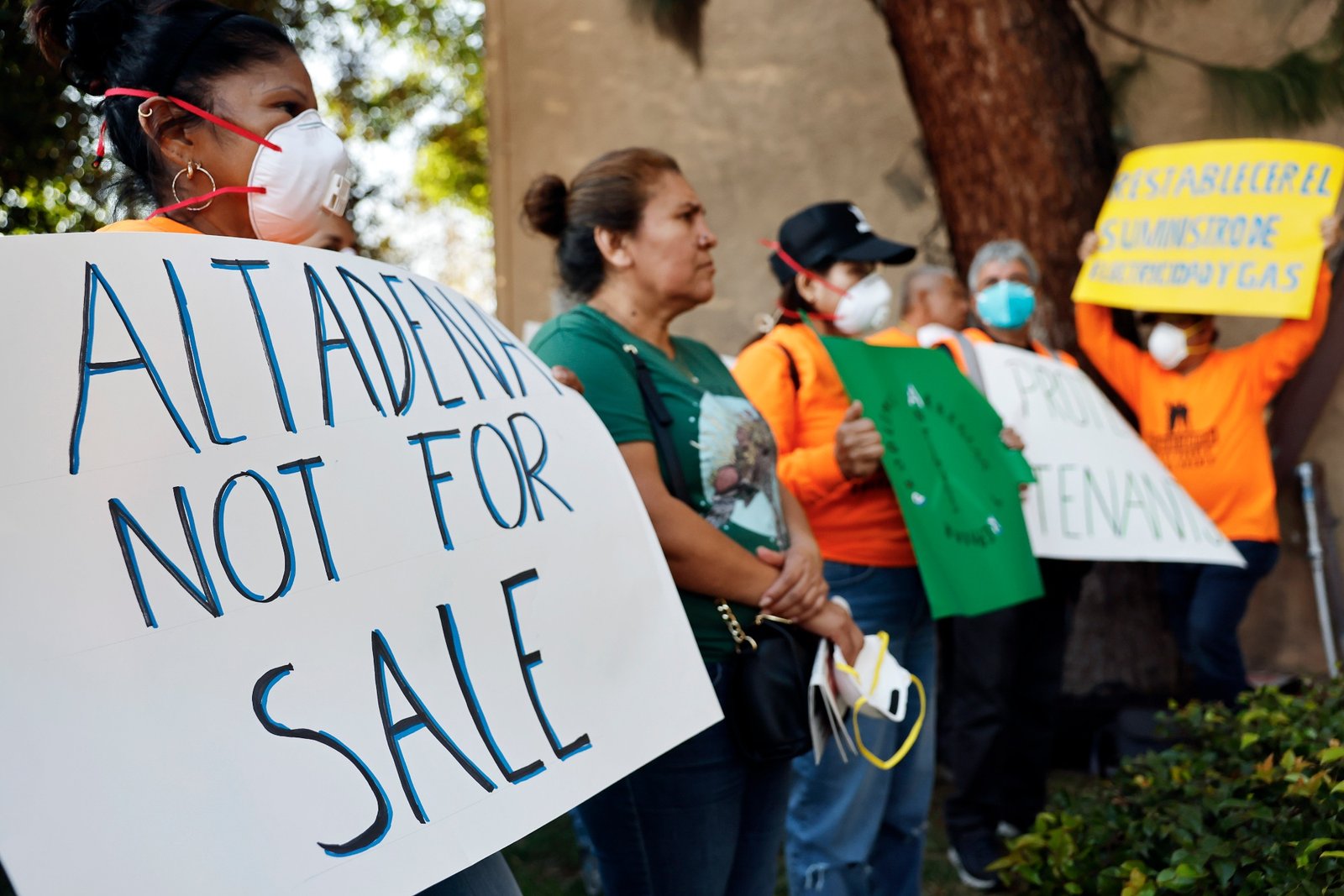 Tenants rally outside of an apartment complex damaged in the Eaton Fire in Altadena, California, in March. They called for the management company and government officials to restore the building's utilities and clean up toxic debris.