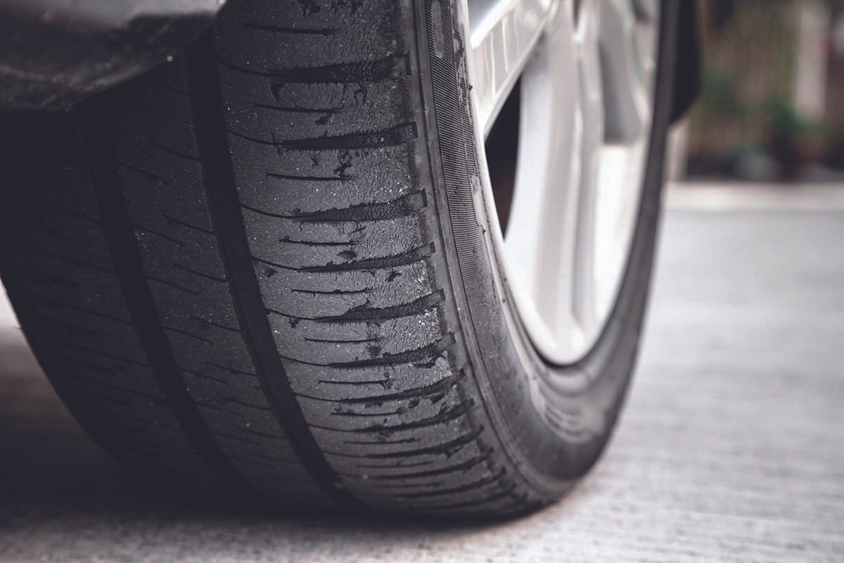 Road-level view of the rear of rear-wheel tyre on a car, in daytime