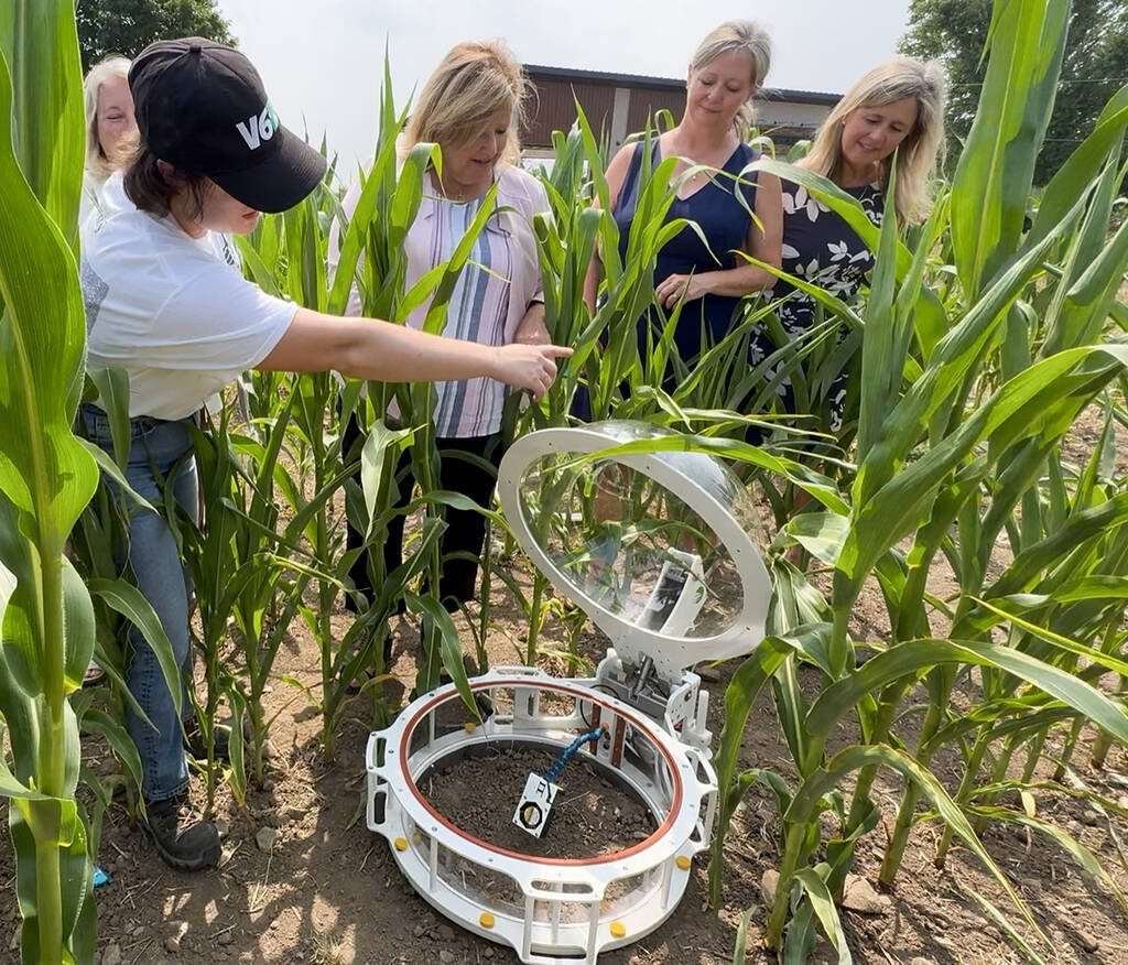University of Trent student researcher, Kaileigh Wright, left, explains to Minister of Rural Affairs, Lisa Thompson, and sisters Deb and Tamara Lightbody, far right, how gas flux is measured as part of the natural-based alternatives for Canada’s fertilizer emissions reduction project at Trent University’s Farm Research Centre.  Photo Diana Martin