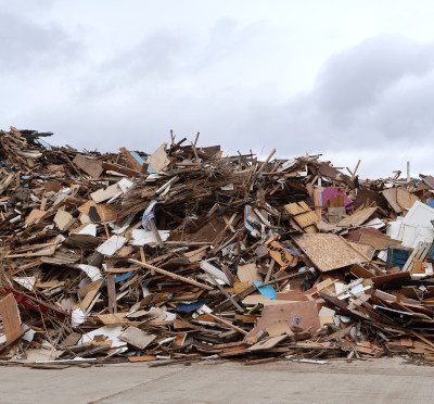 One segment of a large collection of waste wood piled about one-storey high