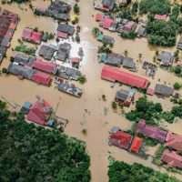 An aerial shot of dirty water flooding a rural village