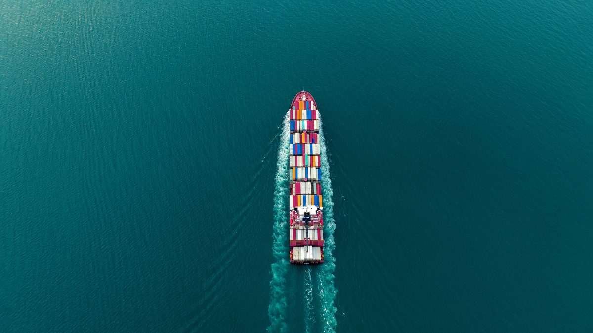 Overhead view of large container ship in transit on deep blue ocean