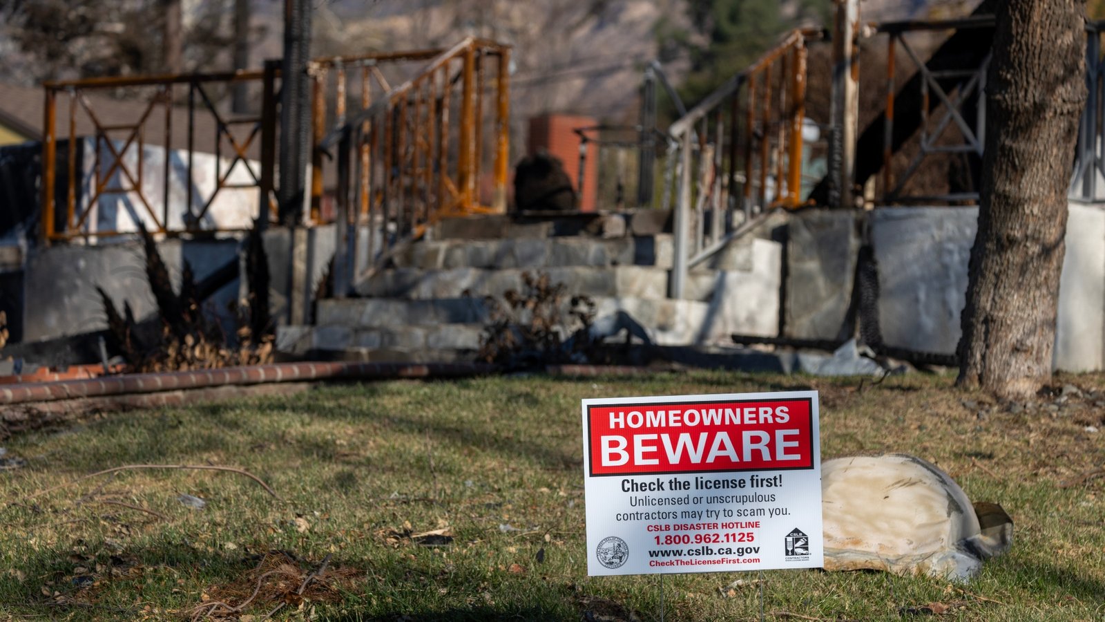 A sign in Altadena, California warns people whose homes burned in the Eaton Fire in January of being approached by unlicensed contractors.