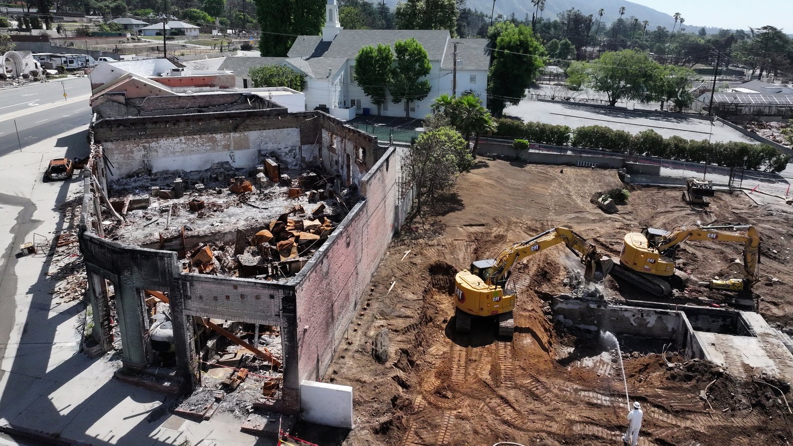 U.S. Army Corps of Engineers contractors clear the remains of a church burned to the ground in the Eaton Fire, as seen in May in Altadena, California.