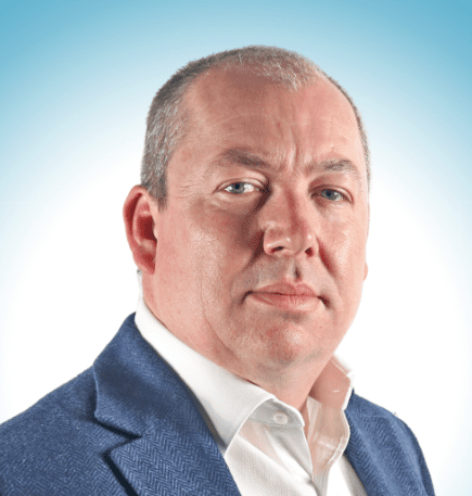 Head and shoulders of a man in business attire looking at the camera