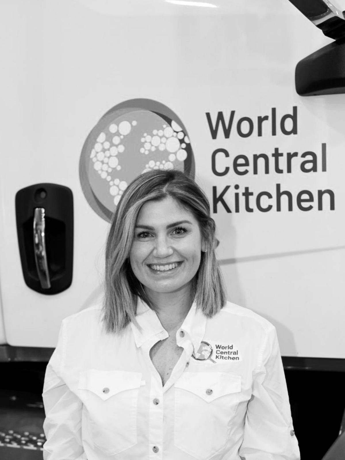 A black and white photo of a woman in front of a world kitchen wall decal or truck