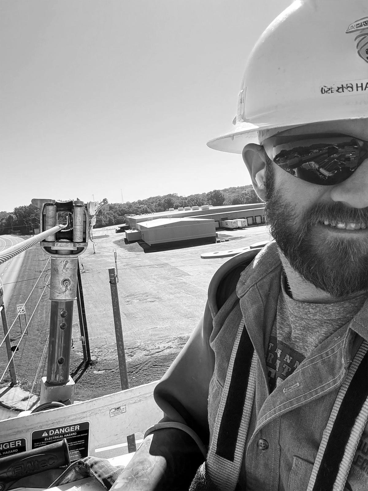 a black and white phot of a man in a hard hat
