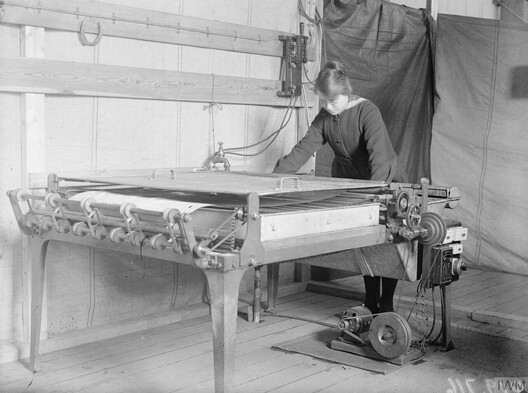 A member of the Women's Royal Naval Service operates a blueprinting machine during World War I. Image © George P. Lewis via Wikipedia under Public Domain