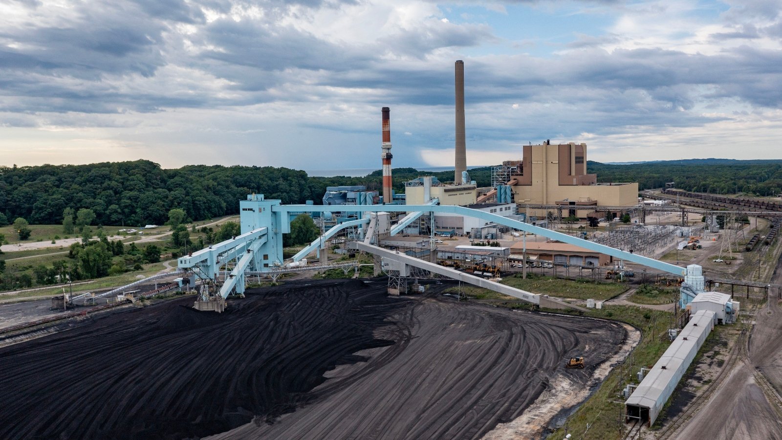 A massive industrial plant stretches over black and gray dirt.