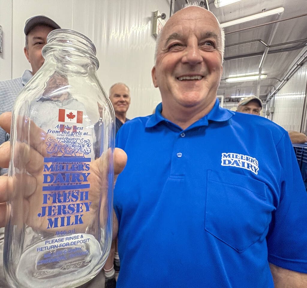 John Miller,  proudly displays the Canadian Flag that adorns the smaller sized glass bottles for their premium Jersey milk products during a tour of the on-farm processing facility near Creemore, Ont. Photo Diana Martin